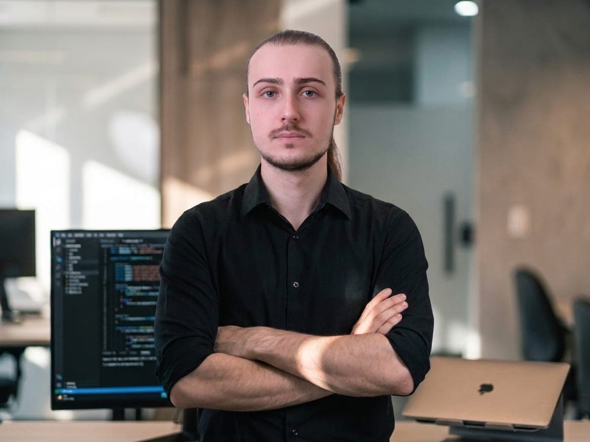 João Guilherme, desenvolvedor da DeepCodeStudio, de braços cruzados no escritório